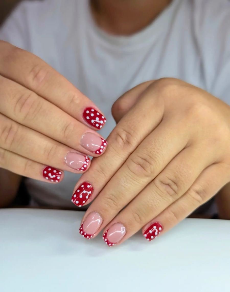 Rotes Nageldesign mit weissen Punkten und French-Spitzen, gemacht bei VELOUR Aesthetic in Lachen SZ
